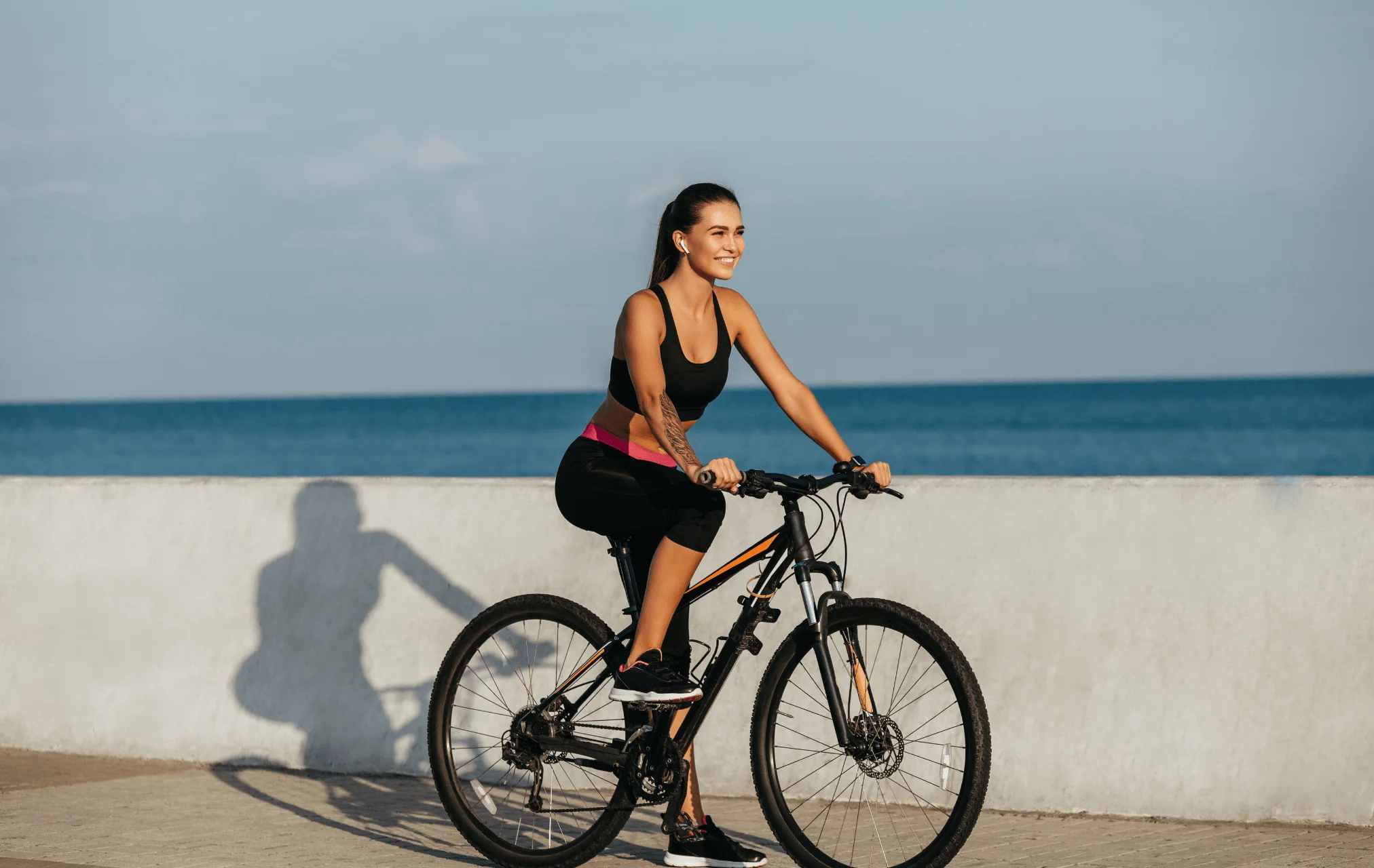 Woman bicycling beside the ocean