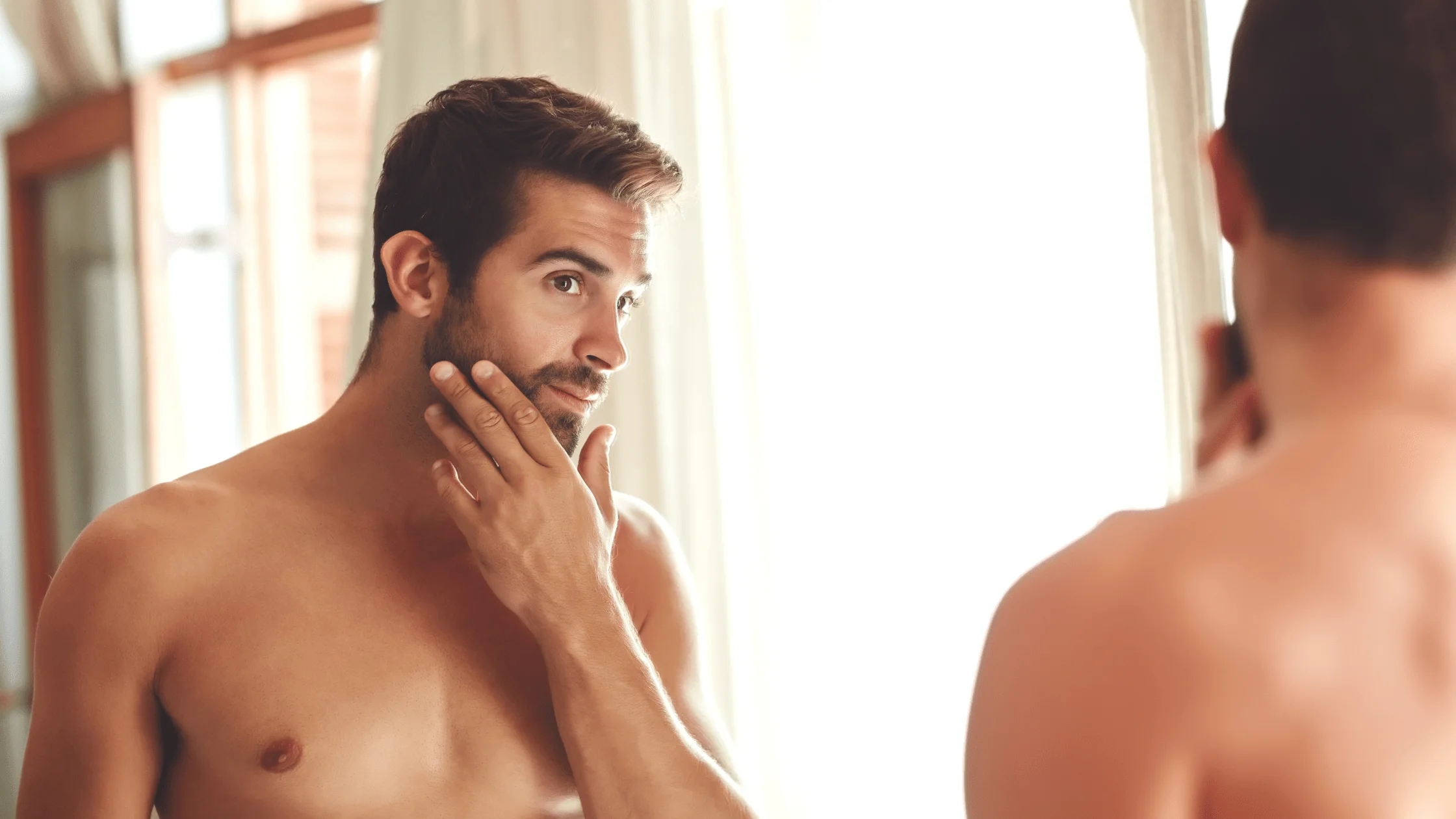 Man examining his face in a mirror