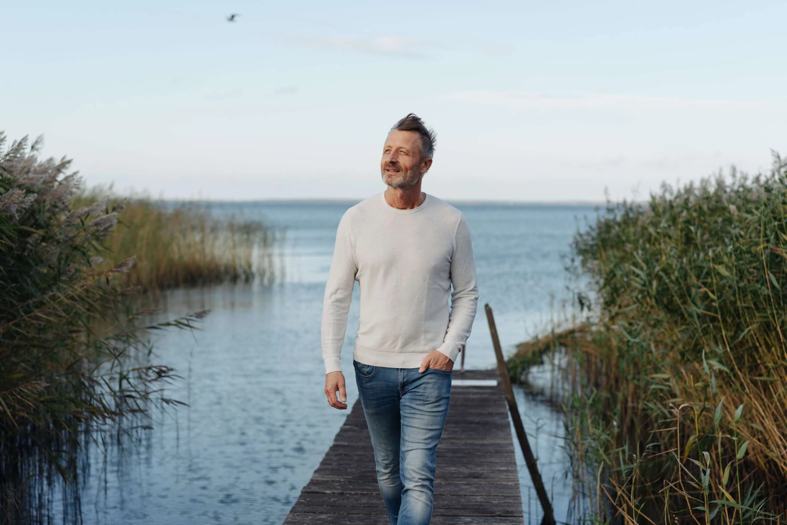 Man walking beside coastal wetlands